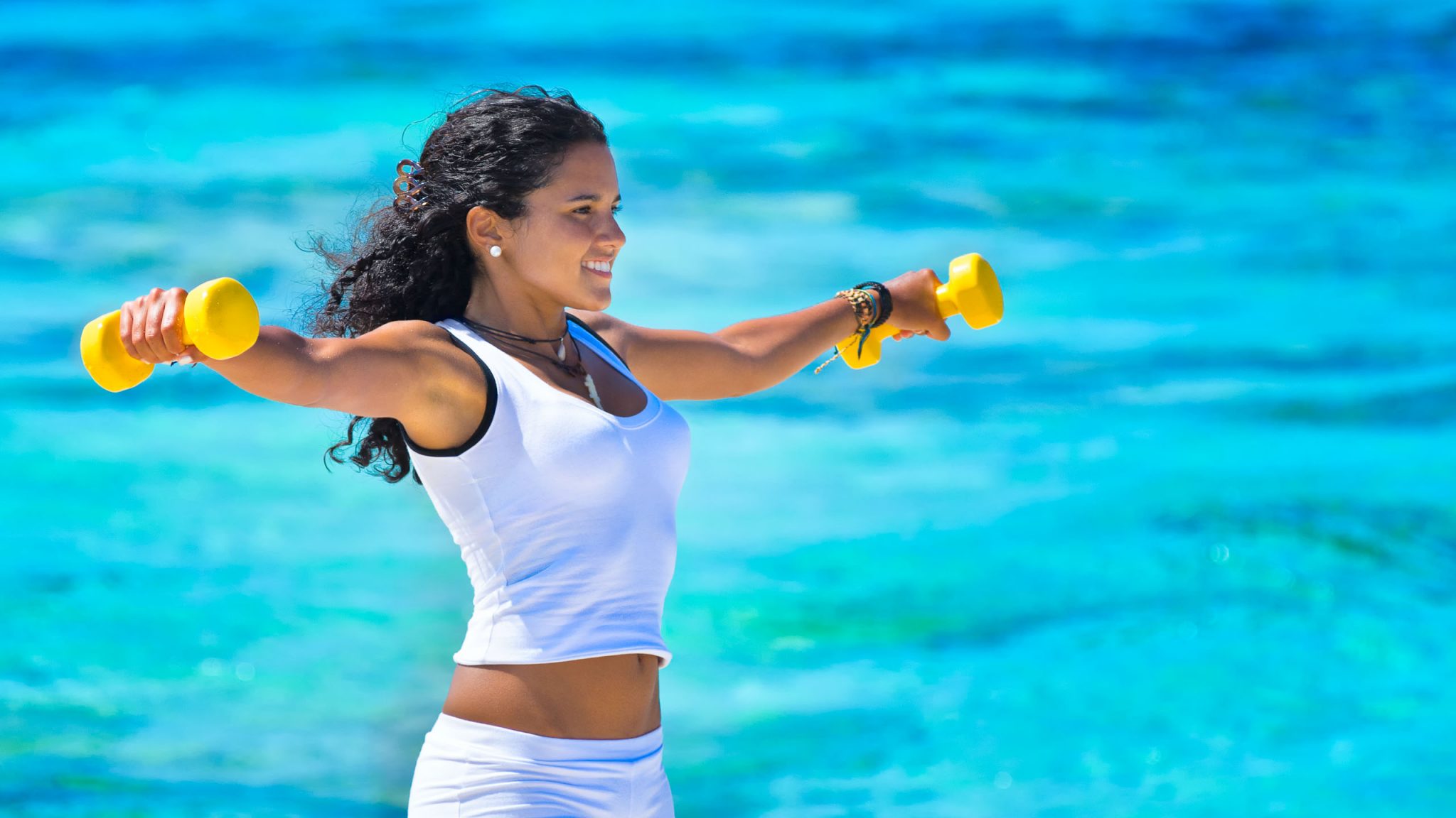 Young woman exercising at a tropical beach
